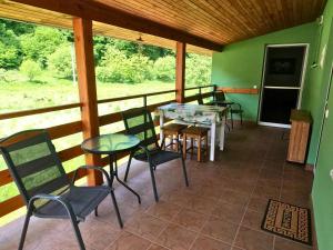 a screened in porch with chairs and a table at Zelený dom pri potoku in Sklené Teplice
