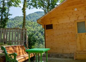 eine Holzhütte mit einer Bank und einem Tisch in der Unterkunft SkyDoor_ცისკარი in Batumi