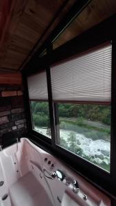 a bathroom with a bath tub and two windows at Sisorti süit bungalov in Rize