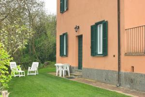 a house with two chairs and a table in the yard at Montecasciano - Papavero in Capranica