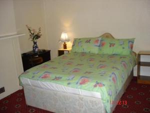 Un dormitorio con una cama y un jarrón de flores. en Victoria Park Hotel, en Mánchester 9 fotos más
