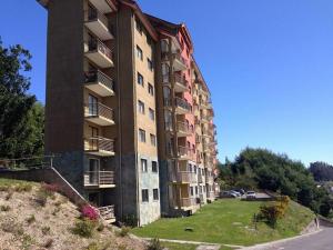 a tall apartment building on a hill next to a street at Mirador Villarrica Apartment in Villarrica