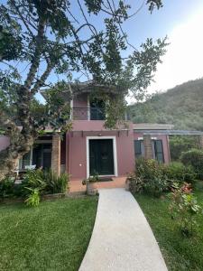 a pink house with a sidewalk in front of it at Gialos Villas 1-2 in Mikros Gialos