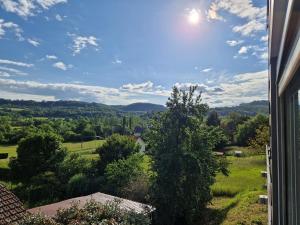 una vista dalla finestra di una casa con un albero di Logement T2 neuf-évasion en Corrèze a Ligneyrac