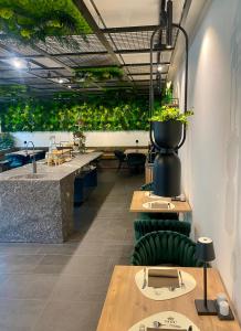 un restaurante con mesas y plantas en el techo en Sole Boutique Hotel en Vipiteno