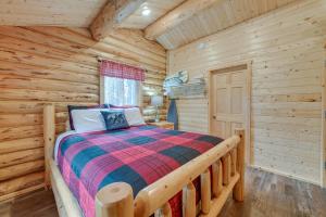 a log cabin bedroom with a bed and a window at Charming Soldotna Cabin Near Kenai River Fishing! in Soldotna