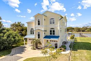 a large white house with a driveway at Sunset Villa in Holden Beach