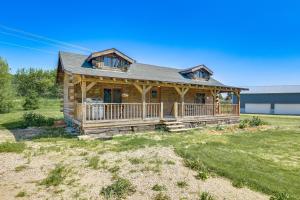 una casa de madera con un gran porche y una casa en Bellevue Log Cabin with Gas Grill and Creek Access, en Bellevue