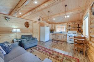 a living room with a couch and a kitchen at Soldotna Fishermans Cabin about 6 Mi to Kenai River in Soldotna