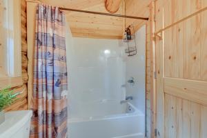 a bathroom with a tub and a shower curtain at Soldotna Fishermans Cabin about 6 Mi to Kenai River in Soldotna