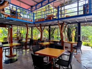 a restaurant with tables and chairs and windows at Talamanca Nature Reserve in Rivas