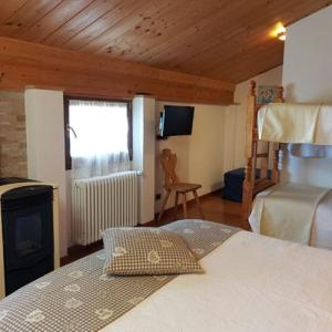 sypialnia z łóżkiem i kominkiem w pokoju w obiekcie B&B La Soldanella w mieście Santo Stefano dʼAveto