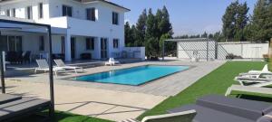 un patio trasero con piscina y una casa en Kiti Village Villa Larnaca, salt-water pool, 5 bedrooms en Kiti