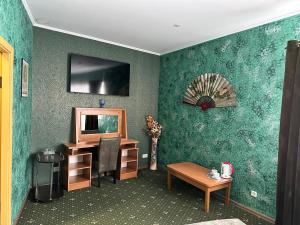 a room with a green wall with a desk and a mirror at RANDEVU in Zhytomyr