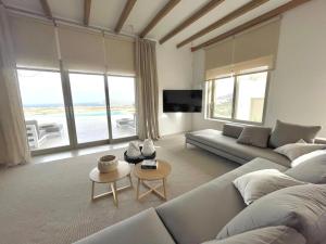 a living room with a couch and a table at Olive Breeze Villa , Naousa in Kampos Paros