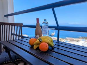 Studio Playa Paraiso Tenerife - ocean view and internet wifi optical fiber - for rent في بلايا بارايسو: حفنة من الموز والبرتقال جالسين على مقاعد