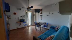 Una sala de estar con un sofá azul y una mesa. en LaCasaDeiGechiOtranto, en Casamassella