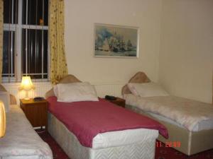 Un dormitorio con dos camas individuales y una ventana. en Victoria Park Hotel, en Mánchester