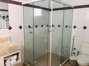 uma cabina de duche em vidro numa casa de banho com WC em Pousada In Garden em Teresópolis