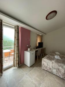 a bedroom with a bed and a desk and a window at Villa Ivanovic in Budva