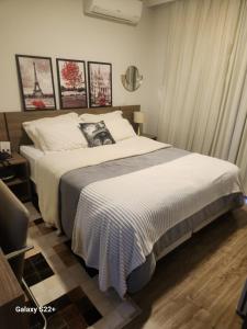 1 dormitorio con 1 cama grande con sábanas blancas en Suíte Barra Olimpica/Rio Centro/Jeunesse Arena., en Río de Janeiro