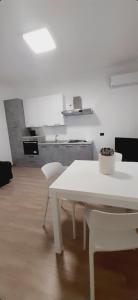 a white kitchen with a white table and chairs at Villa Salvina Beach in Fontane Bianche