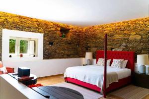 um quarto com uma cama e uma parede de pedra em Quinta da Pousada Casa de Campo em Santa Marta de Penaguião