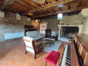 sala de estar con sofá y piano en VILA PEREGRINA-taxi gratis, en Arzúa