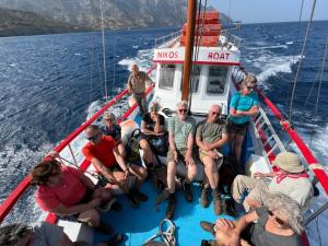 een groep mensen die op een boot in het water zitten bij Nikos Hotel in Diafani