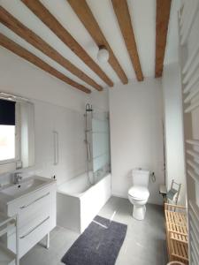 La salle de bains est pourvue de toilettes, d'une baignoire et d'un lavabo. dans l'établissement Charmant studio en centre-ville., à Saint-Pierre-sur-Dives