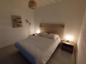 - une chambre dotée d'un lit blanc avec deux lumières dans l'établissement Charmant studio en centre-ville., à Saint-Pierre-sur-Dives