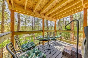 a screened in porch with chairs and a glass table at Ruidoso Cabin Rental with Hot Tub Near Midtown! in Ruidoso