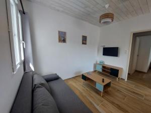 a living room with a couch and a table at Maison de vacances - Classé meublé de tourisme 3 étoiles in L'Ile d'Yeu