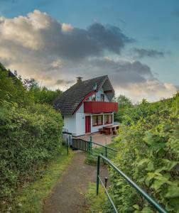 a red and white house with a pathway leading to it at FH Bären Ecke am See im hessischen Bergland in Kirchheim