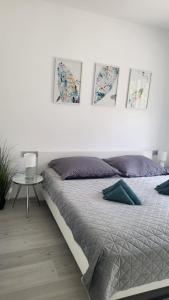 Prázdninový dům u moře في بيليس: سرير في غرفة نوم مع ثلاث صور على الحائط