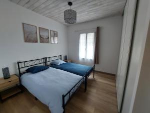 a bedroom with a large bed with blue sheets at Maison de vacances - Classé meublé de tourisme 3 étoiles in L'Ile d'Yeu