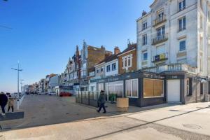 eine Person, die mit Gebäuden eine Stadtstraße hinuntergeht in der Unterkunft La Goélette Malo-les-Bains in Dunkerque