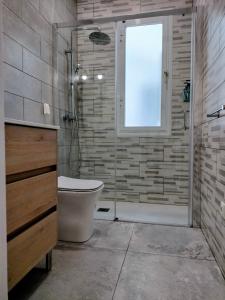 een badkamer met een douche, een toilet en een raam bij Apartamento en el barrio marítimo del Serrallo in Tarragona