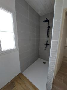 a small bathroom with a shower with a window at Maison de vacances - Classé meublé de tourisme 3 étoiles in L'Ile d'Yeu +7 photos