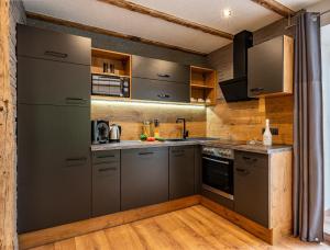 a kitchen with stainless steel appliances and wooden walls at Gasthaus Traube in Bichlbach