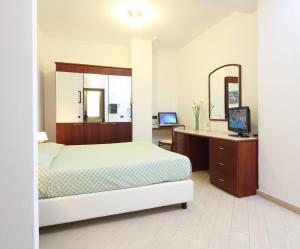 1 dormitorio con cama, escritorio y espejo en Residence Hotel Kriss, en Deiva Marina
