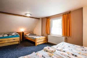 ein Schlafzimmer mit zwei Betten und einem Fenster in der Unterkunft Chalupa Kukajda in Desná