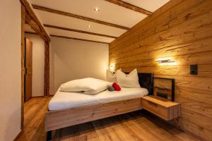 a bedroom with a bed in a wooden wall at Gasthaus Traube in Bichlbach