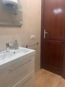 アルゲーロにあるRita's House Algheroの洗面台と木製のドアのあるバスルーム +11枚の写真
