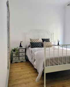 een slaapkamer met een wit bed en een spiegel bij Apartamento en el barrio marítimo del Serrallo in Tarragona