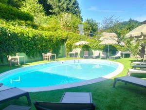 una piscina en un patio con sillas y sombrillas en Albergo Diffuso Locanda Senio, en Palazzuolo sul Senio