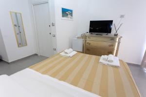 a bedroom with a bed and a tv on a dresser at Residenza Luce Sul Mare in Tropea