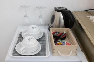a refrigerator with dishes and wine glasses and a tray at Residenza Luce Sul Mare in Tropea
