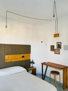 um quarto com uma cama e uma secretária de madeira em Black Market Hotel em Ischia