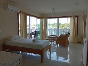 a bedroom with a bed and a balcony at Los Balcones Over The Sea in Carenero